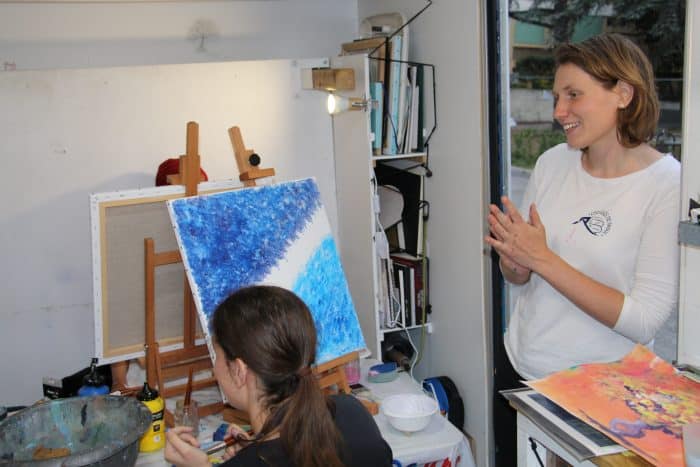 atelier d'art. L'intervenante donne des conseils aux étudiants venus peindre.